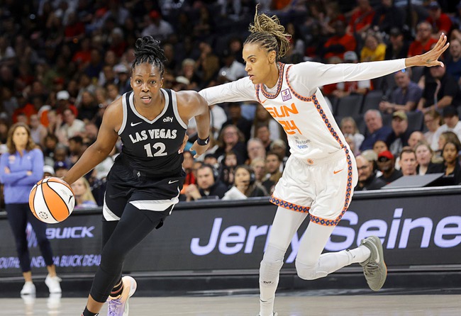 Las Vegas Aces guard Chelsea Gray (12) drives around Connecticut Sun forward DeWanna Bonner (24) during the first half of an WNBA basketball game Sunday, Sept. 15, 2024, in Las Vegas.