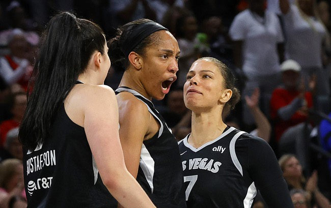 Las Vegas Aces center A'ja Wilson, center, celebrates with Megan Gustafson (17) and Alysha Clark (7) after scoring a basket during the second half of an WNBA basketball game against the Connecticut Sun, Sunday, Sept. 15, 2024, in Las Vegas. Wilson scored 29 points in the game to become the first player in WNBA history to reach 1,000 points in a regular season.