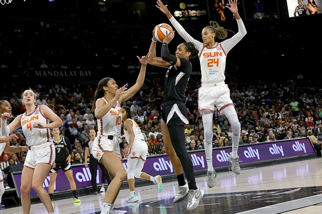 Las Vegas Aces center A'ja Wilson, center, shoots between Connecticut Sun forward Olivia Nelson-Ododa (10) and forward DeWanna Bonner (24)  during the second half of an WNBA basketball game Sunday, Sept. 15, 2024, in Las Vegas. Wilson scored 29 points in the game to become the first player in WNBA history to reach 1,000 points in a regular season.