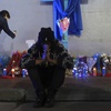 Photo: Sav Bennly sits in front of a memorial at Bourbon 