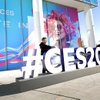 Attendees pose at a CES sign outside the West Hall of the Las Vegas Convention Center during CES 2025 Thursday, Jan. 9, 2025.