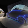 People walk by a Waymo Driver exhibit at the Waymo booth during the 2005 CES tech show in Las Vegas. Waymo says it will switch its existing services in Las Vegas and three other cities to fully autonomous, driverless robotaxi service in the coming weeks. The four cities join 10 other cities where Waymo already offers fully autonomous robotaxi service.