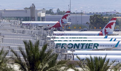 Air Canada and Frontier Airlines passenger jets are shown at terminal 3 gates at Harry Reid International Airport Wednesday, Aug. 13, 2025.