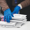 Photo: An election worker sorts mail-in ballots on electi