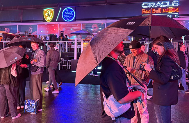 Race fans shelter under umbrellas in the Grand Prix Plaza during the 2025 F1 Las Vegas Grand Prix Friday, Nov. 21, 2025.