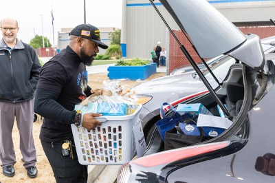Renalto Hardin, with Vegas Youth Ambassadors, in association with NAIOP of Southern Nevada’s community service committee, distributes baskets of food and groceries to families at Walter V. Long Elementary School Friday Nov. 21, 2025.