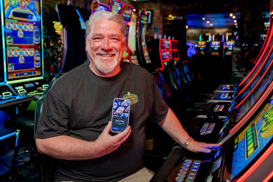 A casino customer displays the Koin app while sitting at a slot machine. App users can scan a QR code to transfer their choice of a monetary amount to gaming devices.