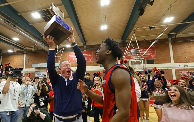 Coronado basketball head coach Jeff Kaufman holds up the trophy after Coronado beat Liberty in the boy’s 5A state championship basketball game at Valley High School Friday, Feb. 20, 2026. Coronado’s Munir Greig (1) is at center. Coronado defeated Liberty 60-55.