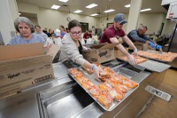 Surrounded by colleagues on an assembly line at the Three Square food bank, Faith Lutheran High School Principal Kat Stokes helped pack lunches for hungry children ...