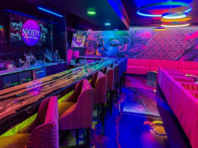 The interior of Society Lounge, a cannabis consumption space on Paradise Road attached to The Grove dispensary, gleams under colorful lighting.
