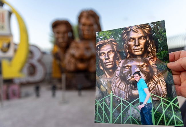 German magician Jochen Stelter displays a 19-year-old photo of himself in front of the Siegfried & Roy statue before a lighting ceremony for the restored 3,600-lb. statue at the Neon Museum Friday, April 24, 2026. The statue, previously located in front of the Mirage on The Strip for more than 30 years, was donated to the museum after Hard Rock International acquired the property.