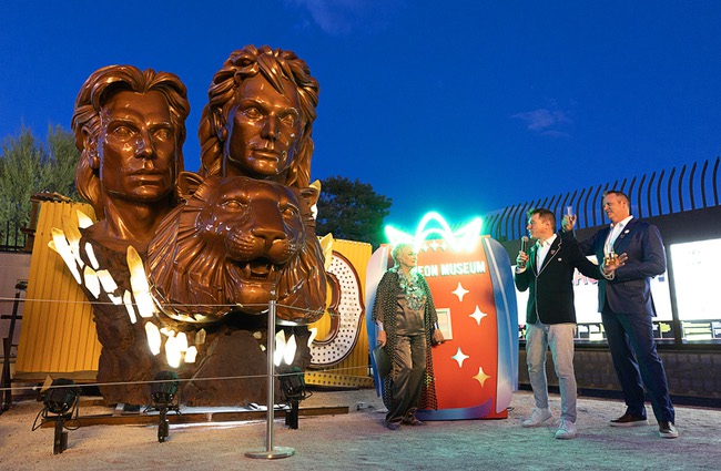 Crystals illuminate as Lynette Chappell, the “evil queen” in the Siegfried & Roy show, flips a switch during a lighting ceremony for the restored 3,600-lb. Siegfried & Roy statue at the Neon Museum Friday, April 24, 2026. Looking on are Aaron Berger, center, executive director/CEO of the Neon Museum, and Adam Barthelmess, museum board chairman. The statue, previously located in front of the Mirage on The Strip for more than 30 years, was donated to the museum after Hard Rock International acquired the property.