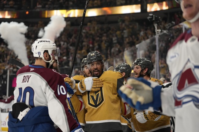 Vegas Golden Knights right wing Keegan Kolesar, second from left, is held back after Colorado Avalanche defenseman Josh Manson, right, shoved him into the boards after Kolesar scored during the second period in Game 3 of the Western Conference finals NHL hockey Stanley Cup playoff series Sunday, May 24, 2026, in Las Vegas.