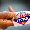 Photo: An election worker holds out an I Voted sticker du