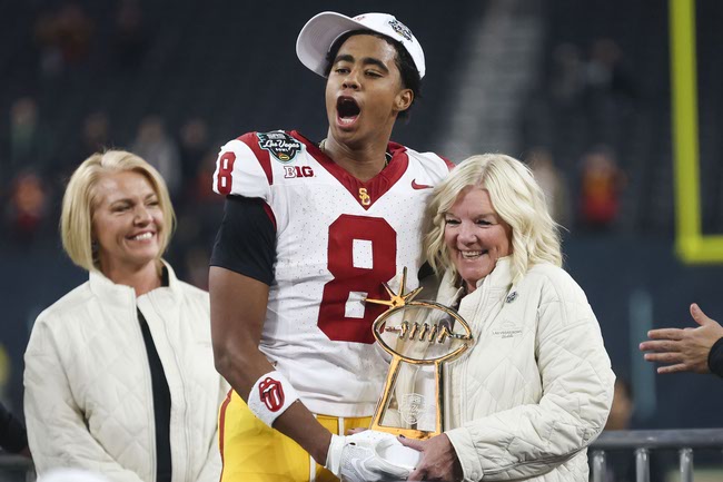 USC Trojans wide receiver Ja'Kobi Lane (8) holds a Most Valuable Player trophy with Las Vegas Bowl Executive Leslie Forman after the USC Trojans defeat the Texas A&M Aggies, 35-31, in a Las Vegas Bowl college football game at Allegiant Stadium, Friday, Dec. 27, 2024. WADE VANDERVORT