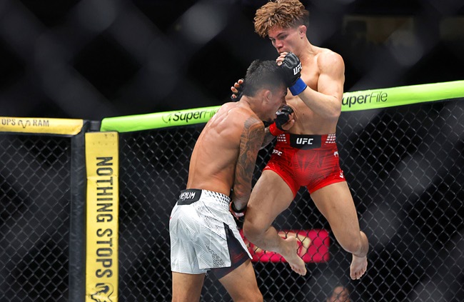 Lone’er Kavanagh jumps up to knee Brandon Royval in a flyweight bout during UFC 329 at T-Mobile Arena Saturday, July 11, 2026. Royval defeated Kavanagh by submission in the third round.