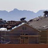 Photo: Roofers work on new homes at a residential constru