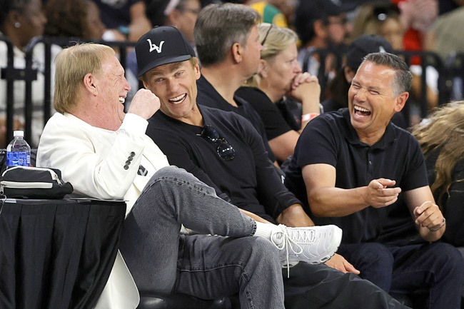 Las Vegas Aces owner Mark Davis, left, minority owner Tom Brady, center, and wellness coordinator Alex Guerrero of the Las Vegas Raiders laugh during the first half of an WNBA basketball game between the Las Vegas Aces and the Portland Fire at Michelob Ultra Arena in Mandlay Bay Tuesday, July 28, 2026. 