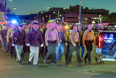 Law enforcement officers, firefighters, rescue workers and other people take part in a procession from University Medical Center to the Clark County Coroner’s Office after a Metro Police officer was shot and killed Tuesday, Aug. 4, 2026. Sheriff Kevin McMahill is at far&nbsp;right.