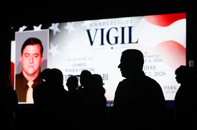 People gather by a sign paying tribute to slain Metro Police officer Austin Abdelnabi during a vigil at Police Memorial Park Friday, Aug. 7, 2026. Officer Abdelnabi was shot and killed in the line of duty on Tuesday, Aug. 4.