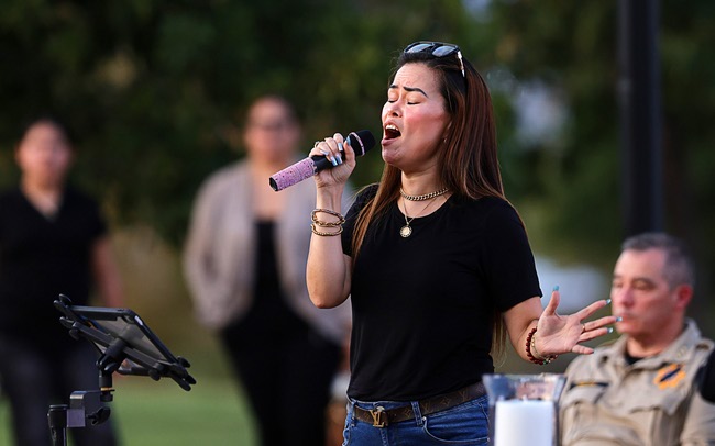 A women signs a tribute song during a vigil for slain Metro Police officer Austin Abdelnabi at Police Memorial Park Friday, Aug. 7, 2026. Officer Abdelnabi was shot and killed in the line of duty on Tuesday, Aug. 4.